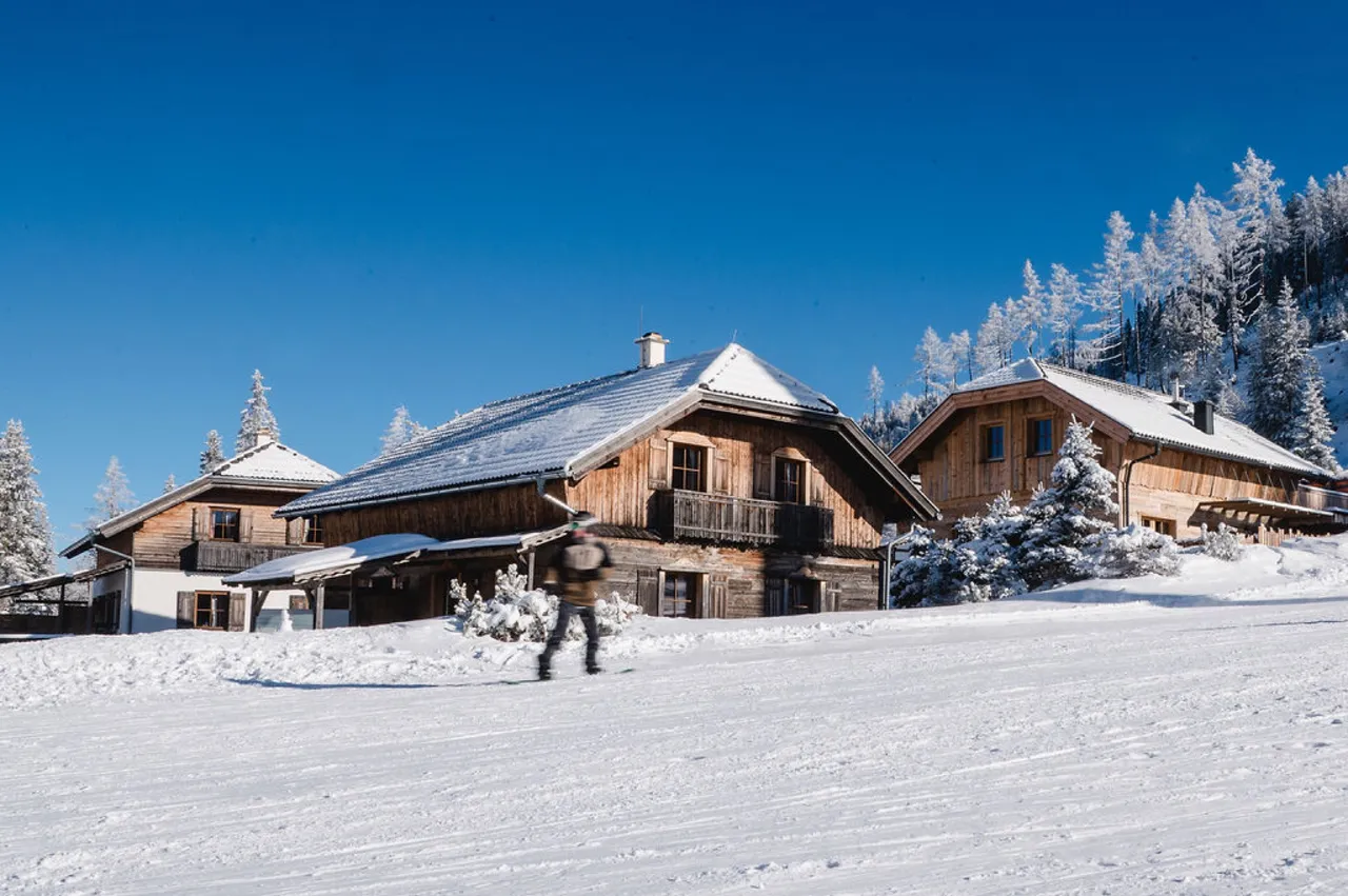 Verschneite Almchalets am Katschberg unter blauem Himmel