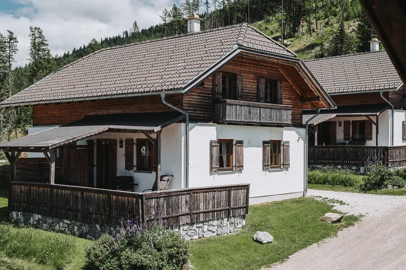 Almhütte mit überdachter Terrasse an einem Sommertag
