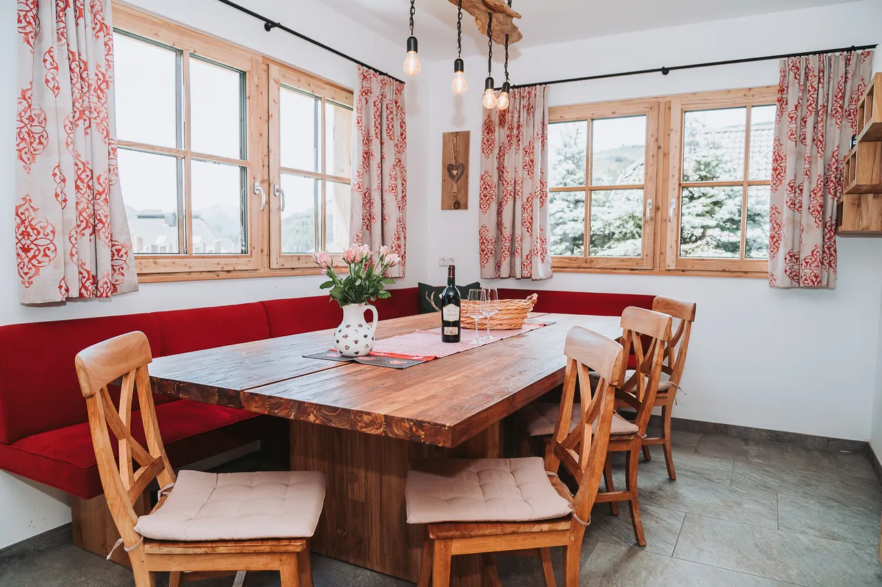 Essbereich mit roter Eckbank und Holztisch im Chalet Panorama