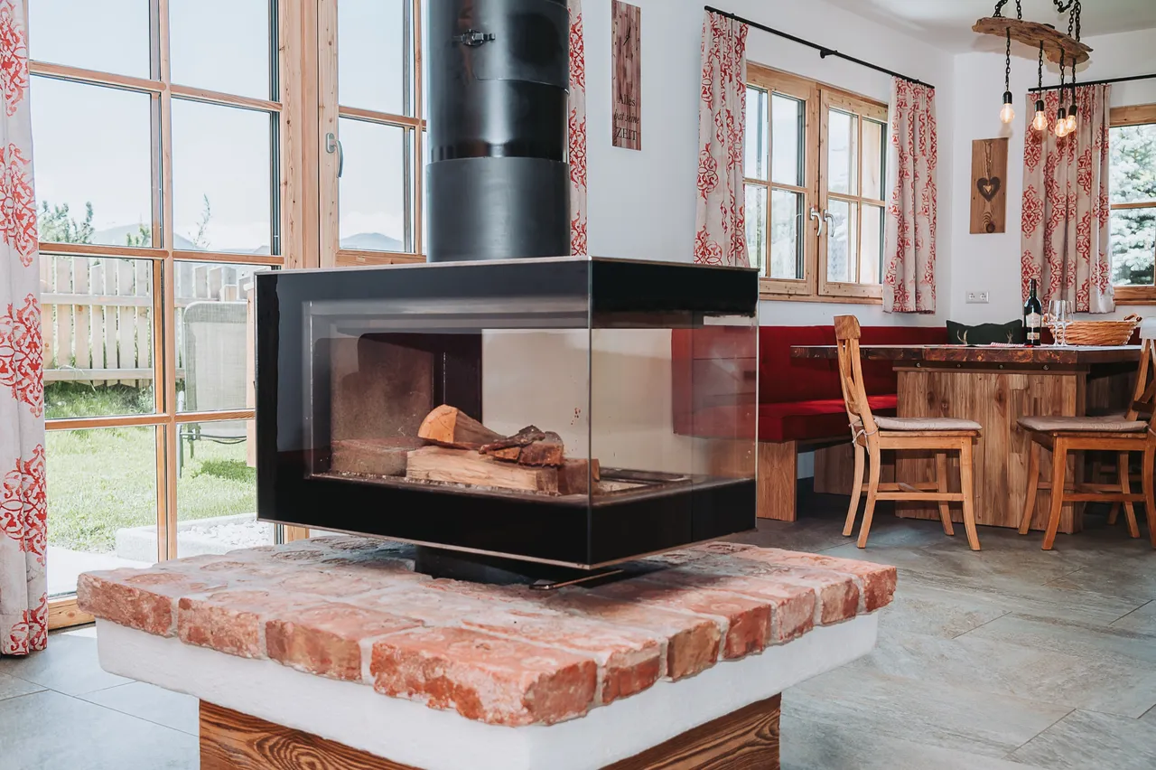 Schwebekamin über einem Sockel aus Ziegeln im hellen Wohnraum