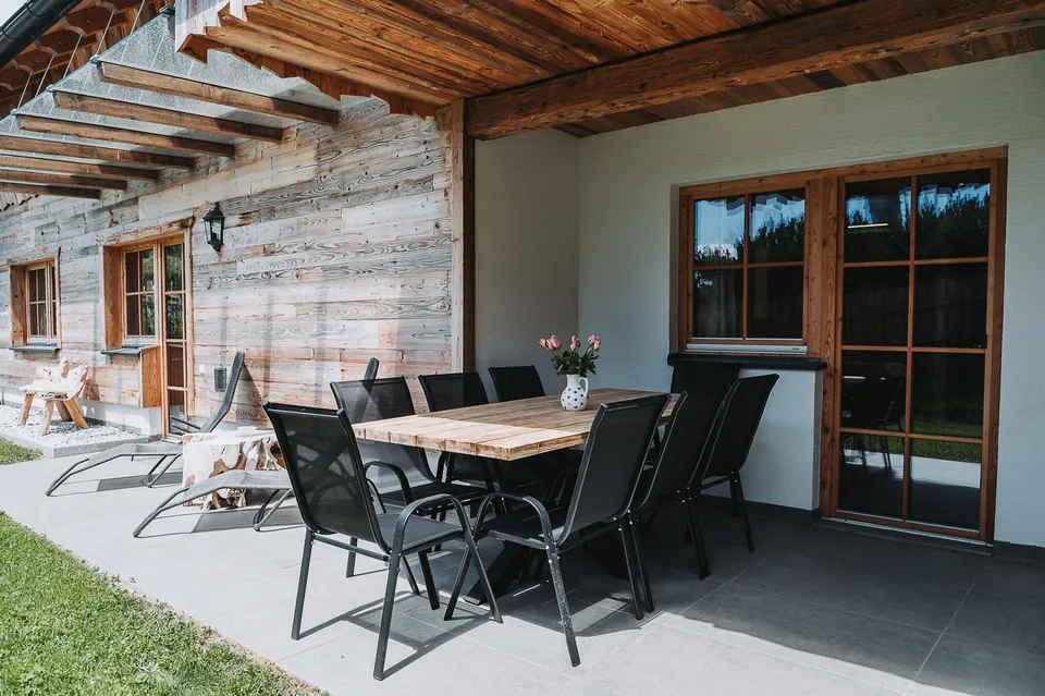 Überdachte Terrasse mit großem Esstisch am Chalet Panorama