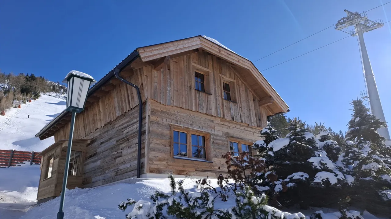 Chalet Katschberg Panorama im Schnee, daneben Laterne und Liftmast