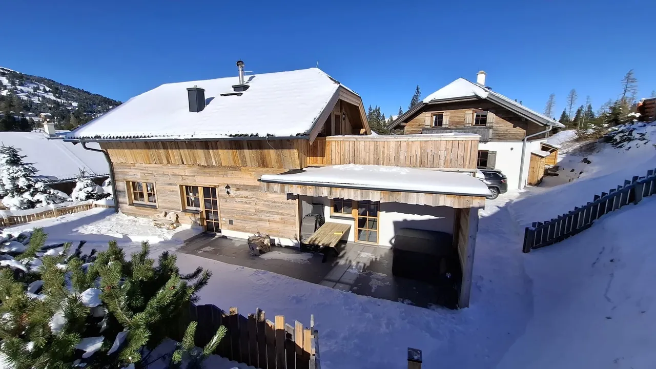 Chalets mit verschneiten Dächern und Terrasse im Almdorf Katschberg