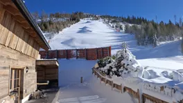 Verschneiter Weg am Chalet Panorama mit Blick auf die Piste