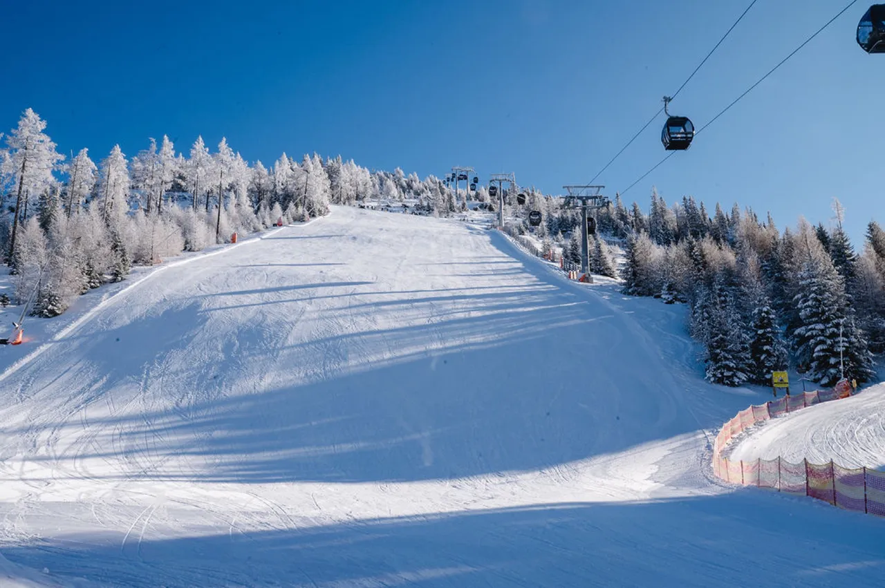 Präparierte Skipiste am Katschberg mit Gondelbahn unter blauem Himmel